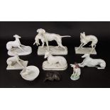 A collection of continental and other white glazed models of dogs including a Nymphenburg group of a