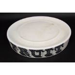 A cream glazed circular stand with black and white printed inscription, 'Fruit' with printed mark to