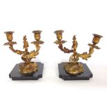 A pair of French ormolu twin branch candelabra with typical scrolled Rococo acanthus decoration upon