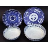 Two oriental blue and white dishes, one showing figures walking in a wooded landscape, the other