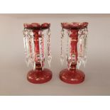 A pair of 19th century cranberry glass lustres, with painted floral overlay and gilded highlights