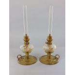 A pair of brass and cut glass oil lanterns, with cut glass reservoirs and scrolled handles, 40cm