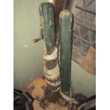 A pair of vintage wooden tennis posts with winding net mechanism and weathered green painted