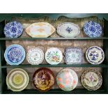 A collection of mainly continental tin glazed earthenwares including chargers and dishes, a pair