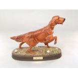 A Beswick matt glazed model of a Irish setter raised on an oval base