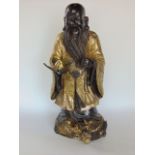 Chinese bronze and gilt study of a sage holding a peach upon a dragon, 36 cm high