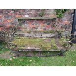 Three old bespoke blacksmith made low garden benches of varying size with open scrollwork detail,