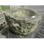 A carved and weathered rough hewn stone mortar/planter of circular form 40 cm diameter approx