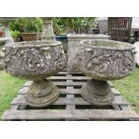 A pair of weathered cast composition stone garden planters with circular and tapered scrolled