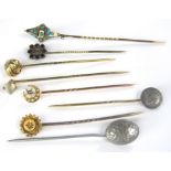 A collection of gold and silver stick pins to include a seed pearl and sapphire pin in the form of a