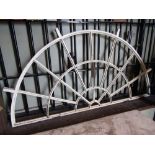 A cream painted cast iron framed fan light with segmented vacant panels approx 4ft wide x 2ft high