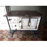 A reclaimed cast iron and enamel two ring stove with decorative Art Nouveau style floral