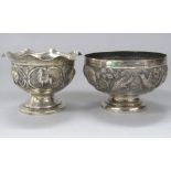Two similar eastern white metal pedestal bowls, each embossed with wildlife to include elephants,