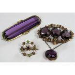 Two Victorian amethyst coloured brooches together with a further brooch of suffragette colours set