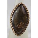 A marquise shaped mourning ring encasing woven hair and gilt monogram, with blue enamel border and