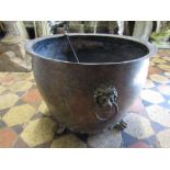 An old copper coal bucket of circular form with riveted seams, applied lions mask and ring handles