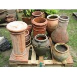 A reclaimed terracotta chimney pot of cylindrical form, a small chimenea with grape and vine