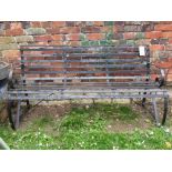 A heavy iron work three seat garden bench, with open strap work seat combined back and scrolled