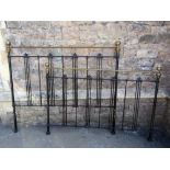 A Victorian style cast iron double bedstead with brass finials and vertical rails (kingsize)