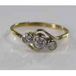 An 18ct three stone diamond crossover ring, central stone 0.20cts approx, 2g