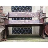 A rustic two seat garden bench with pegged frame and stained finish