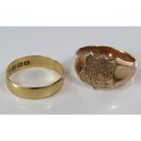 An 18ct wedding ring together with a yellow metal shield signet ring engraved with monogram, sizes N