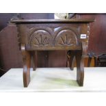 An oak sewing box in the form of an old English style box stool, with hinged lid and carved frieze