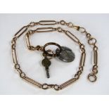 A 9ct chain with oval links suspending a brass gaming token and watch key, chain 33g