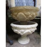 A pair of cast composition stone garden urns of squat circular form with acanthus detail raised on