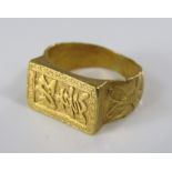 A yellow metal far eastern signet ring decorated with relief moulded butterflies to the shank,