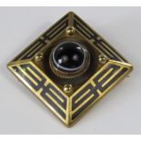 A banded agate yellow metal brooch of square form with geometric black enamel border, 14.5g