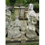 A weathered contemporary cast composition stone bird bath support in the form of a seated cherub,