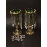 A pair of Victorian green glass lustres, with scrolled gilt overlay and prismatic crystal drops,