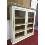 A painted pine framed kitchen cabinet enclosed by a pair of rectangular segmented glazed and moulded