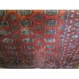 Bokhara type rug, with geometric medallions upon a red ground, 180 x 125 cm