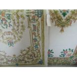 Two similar Chinese wool rugs each decorated with blue and pink foliage upon a cream ground, the