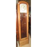 An early 20th century cigar shaped long case clock with moulded case enclosed by a bevelled edge