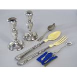 A mixed collection of silver to include two silver candlesticks and a collection of various