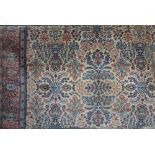 An Axminster carpet in the Persian style with beige ground field and repeating floral detail