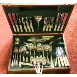 An oak canteen part fitted with a collection of silver plated cutlery; together with four silver tea