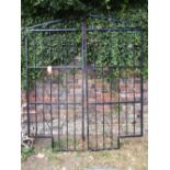 A pair of fabricated steel entrance gates with angular and stepped frames and simple scrollwork
