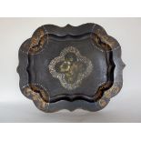 A Victorian ebonised papier mache tray, inlaid with mother of pearl and decorated with floral