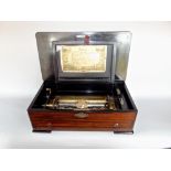 A 19th century rosewood and boxwood inlaid music box, the hinged lid inlaid with a lighthouse and