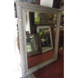 A large contemporary wall mirror of rectangular form with bevelled edge plate within a moulded frame