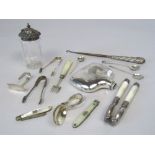 A mixed collection of silver to include an antique folding mother of pearl and silver fork, silver