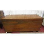 A teak chest/box of rectangular form with hinged lid, side carrying handles and raised on later