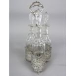 An attractive white metal, three bottle decanter/cruet stand, with hoop handle cast with scallop