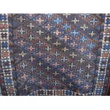 Persian rug decorated with blue and brown alternating diaper patterns upon a rich brown ground,