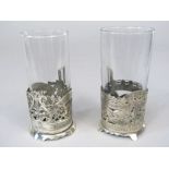 A pair of Russian white metal cups sleeves, pierced with a lyre and scrolled foliage, 7.5cm high (