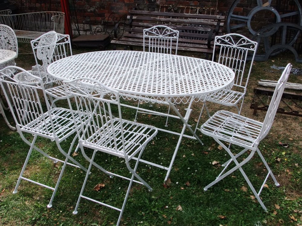 A steel framed garden table of oval form with lattice top raised on folding x framed supports,